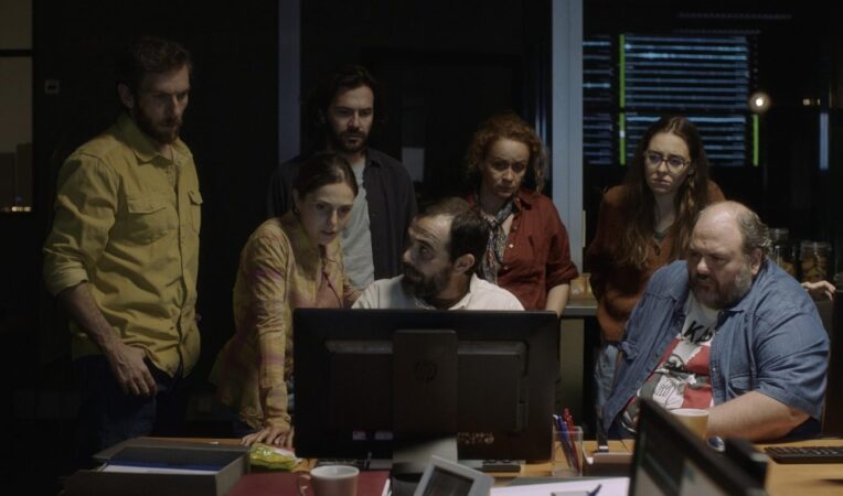 Grupo de personagens apreensivos em volta de um computador no filme O Melhor dos Mundos, destaque das estreias da semana na HBO Max