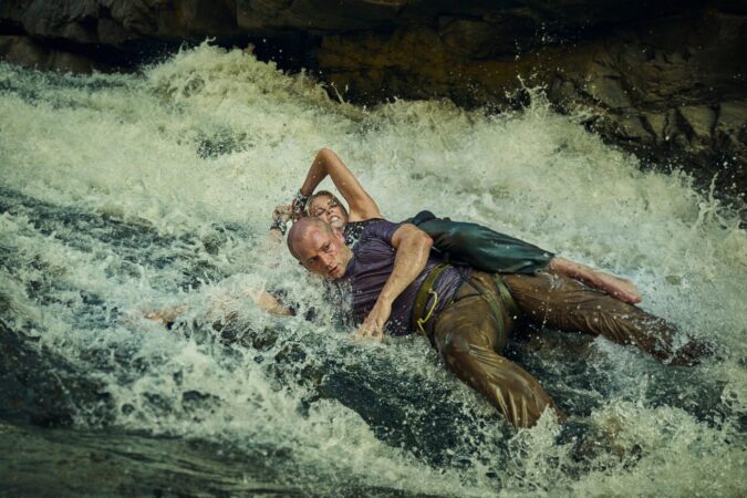 Cena de ação com Charlize Theron em águas agitadas no filme O Jogo do Predador