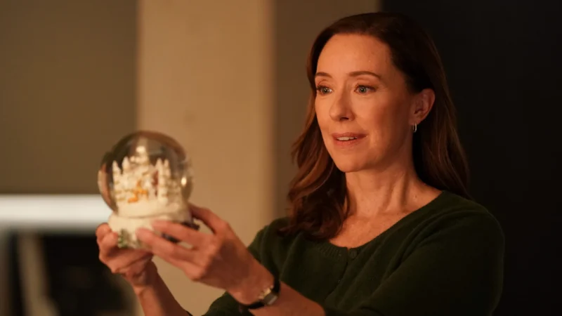 Molly Parker como Dra. Amy Larsen segurando um globo de neve com expressão reflexiva em DOC Temporada 2
