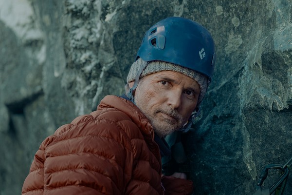 Eric Bana como Tommy em cena de escalada na Noruega no filme O Jogo do Predador, crítica e prólogo.
