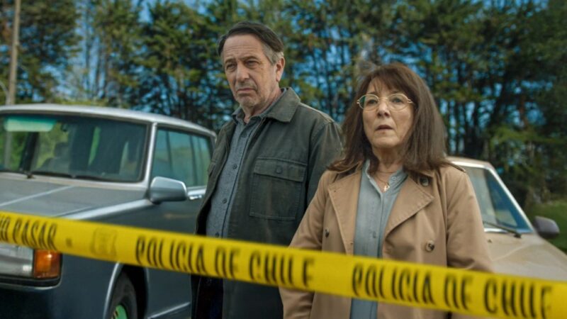 O ator Alfredo Castro e a protagonista em uma cena de crime isolada por fita amarela da polícia chilena na série Alguém tem que Saber, um dos destaques de os melhores filmes e séries de abril na Netflix
