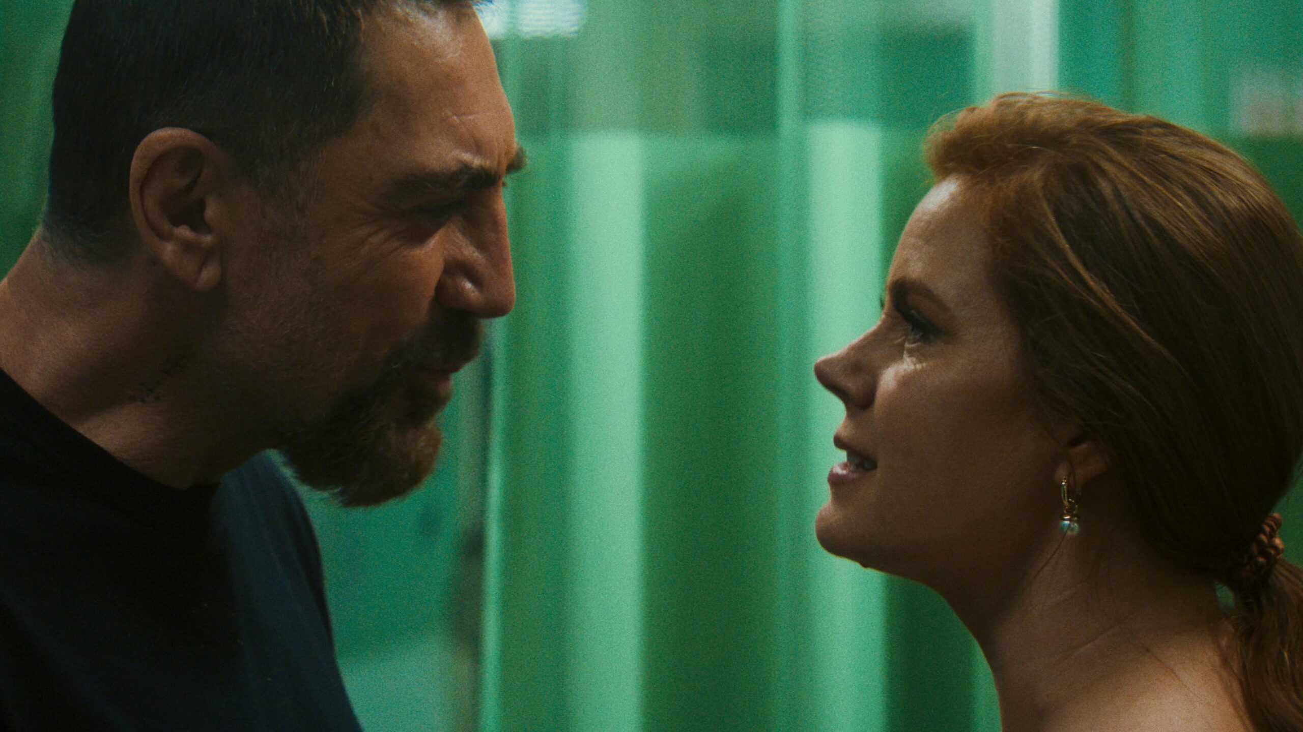 Javier Bardem encara Amy Adams com expressão agressiva e de perfil em cenário de hospital com cortina verde ao fundo, ilustrando as novidades dos streamings.