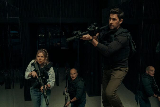 John Krasinski, Sienna Miller e Michael Kelly empunhando armas táticas em uma sala espelhada escura em cena do filme Tom Clancy's Jack Ryan: Ghost War, destaque entre as estreias nos streamings da semana.