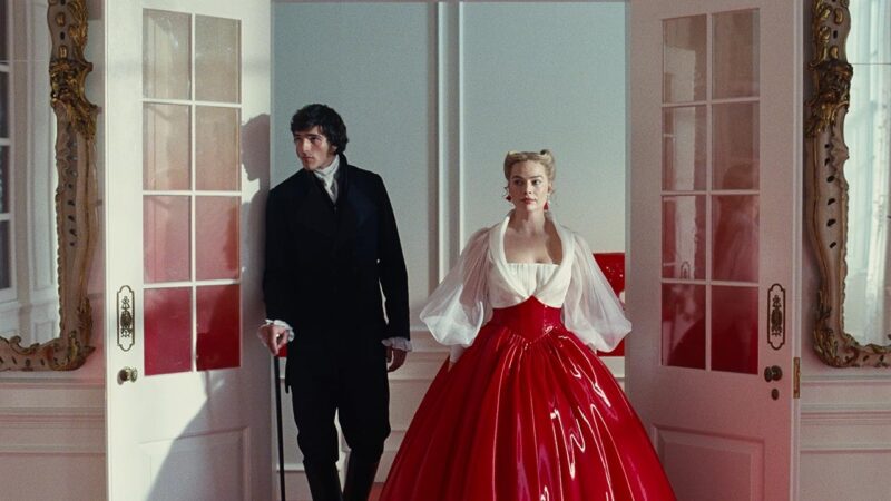 Jacob Elordi e Margot Robbie com vestido vermelho bufante em cena de O Morro dos Ventos Uivantes 2026