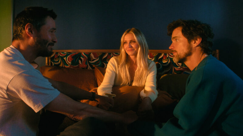 Keanu Reeves, Cameron Diaz e Matt Bomer sentados em uma cama em uma cena do filme Consequência, um dos destaques na curadoria de os melhores filmes e séries de abril.