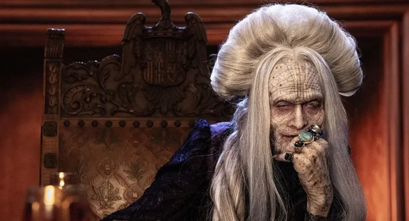 Drácula de Luc Besson: ator Caleb Landry Jones caracterizado com maquiagem pesada de vampiro idoso e cabelos brancos volumosos.