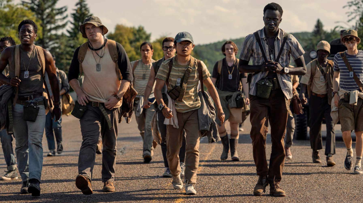 Grupo de adolescentes caminhando por uma estrada ensolarada no filme A Longa Marcha, uma das escolhas de os melhores filmes e séries de abril no Telecine.