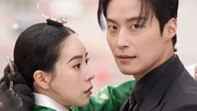 Casal protagonista do dorama My Royal Nemesis em um abraço, destacando o contraste entre o traje tradicional coreano e o terno moderno