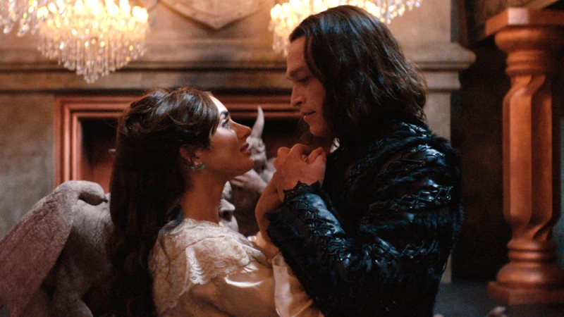 Caleb Landry Jones como Drácula de Luc Besson e Zoe Kravitz de mãos dadas em cena do filme Drácula: Uma História de Amor Eterno