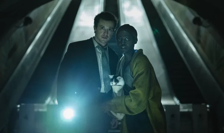O que assistir nos streamings: os atores Joseph Quinn e Lupita Nyong'o com um gato em cena do filme Um Lugar Silencioso: Dia Um.