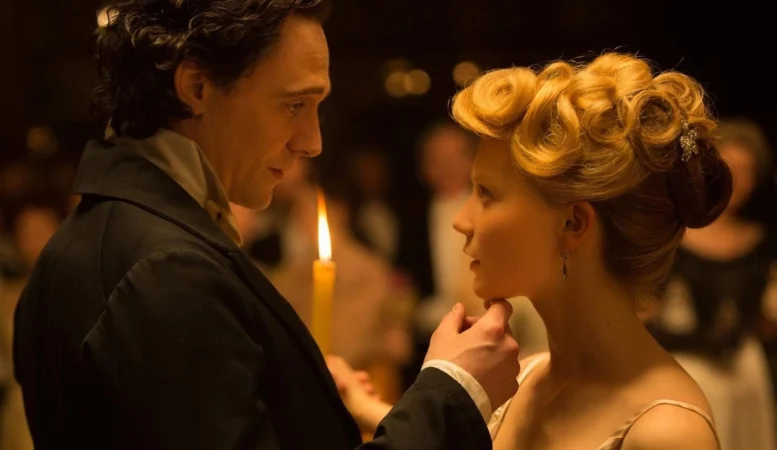 Tom Hiddleston e Mia Wasikowska segurando uma vela em cena de A Colina Escarlate, um clássico moderno entre os romances góticos.