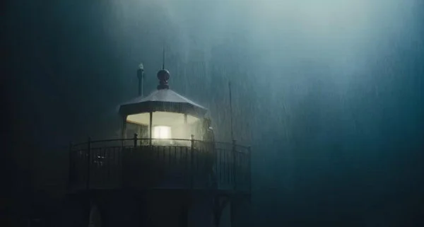 Farol iluminado sob tempestade e névoa pesada em cena de O Segredo de Widow's Bay.