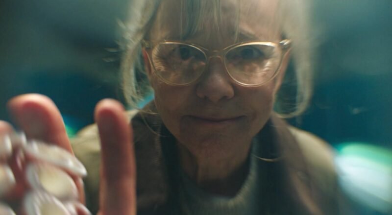 Close-up de Sally Field olhando fixamente para um tentáculo de polvo no vidro, desvendando o significado de Criaturas Extraordinariamente Brilhantes.