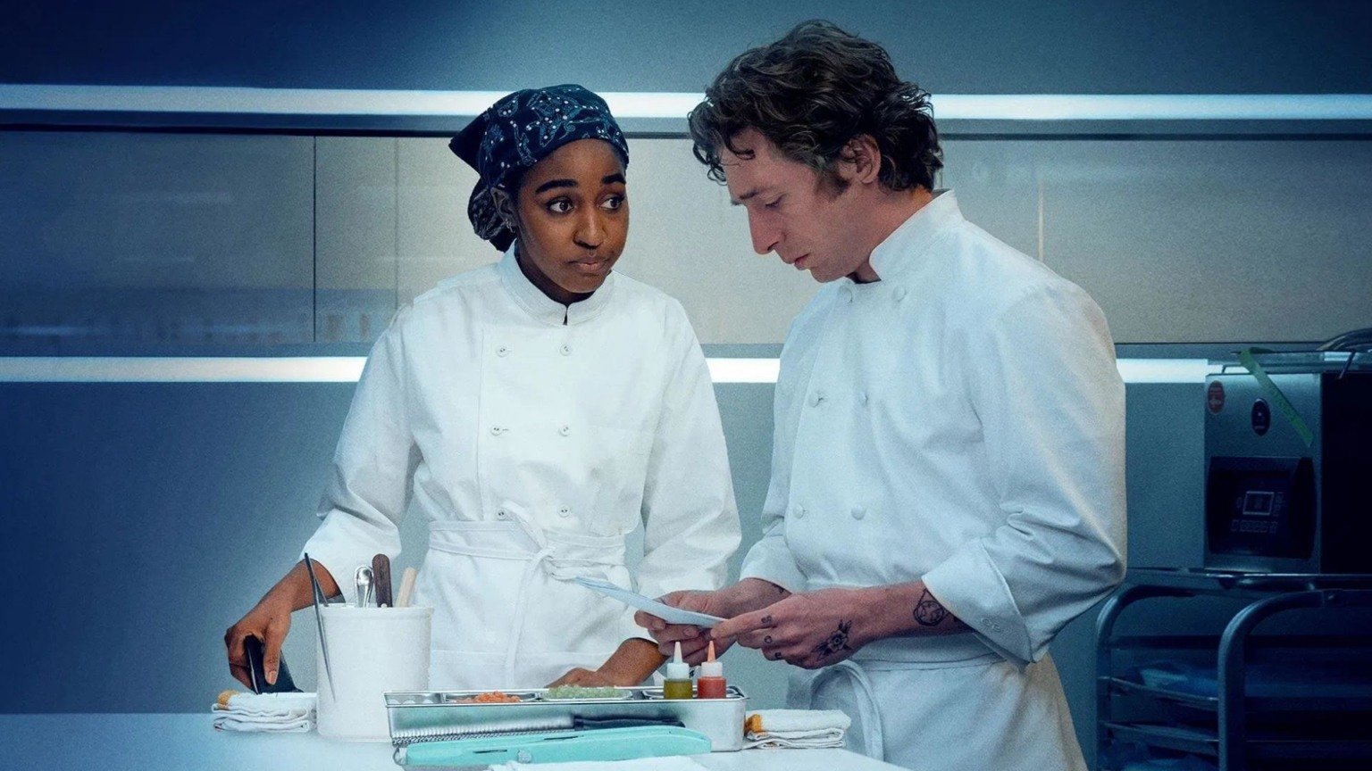 Cena da série O Urso em destaque nas estreias de junho nos streamings, mostrando os chefs Sydney e Carmy na cozinha no final da temporada 5.