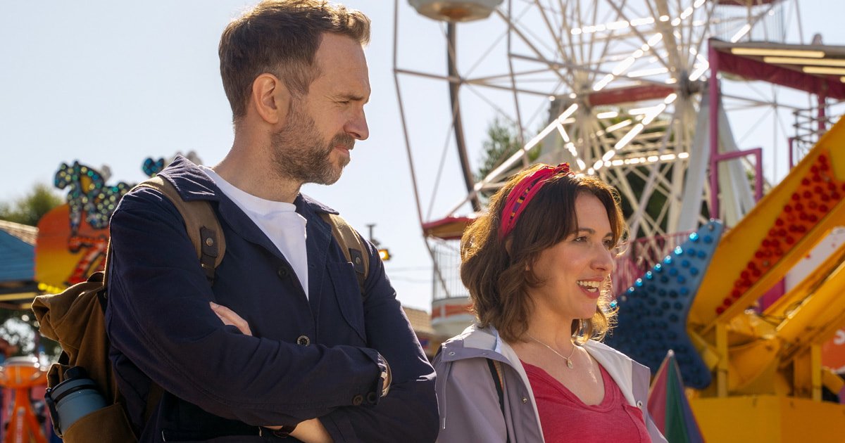 Rafe Spall e Esther Smith sorrindo em um parque de diversões na série Trying, destaque entre as estreias do streaming.