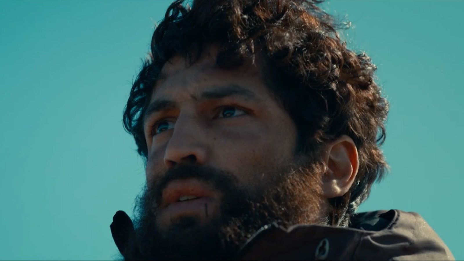 Gabriel Leone com barba e olhar compenetrado em cena do filme Barba Ensopada de Sangue, destaque dos lançamentos de julho.