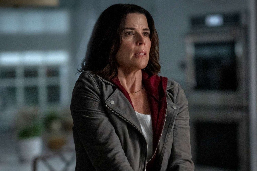 Neve Campbell assustada em cena de suspense dramático para o guia de estreias do streaming.
