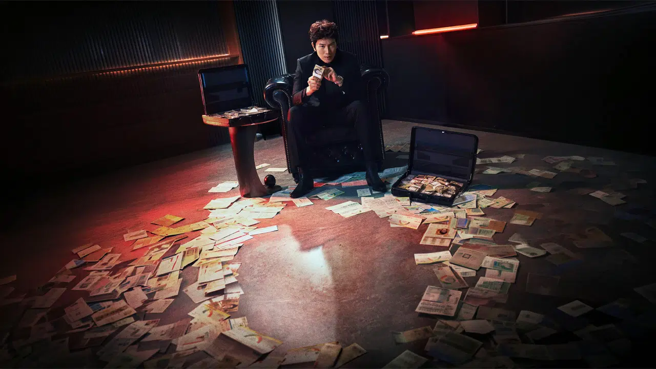 Ji Sung cercado por notas de dinheiro no chão em cena de The Apartment Job, grande lançamento entre as estreias do streaming.