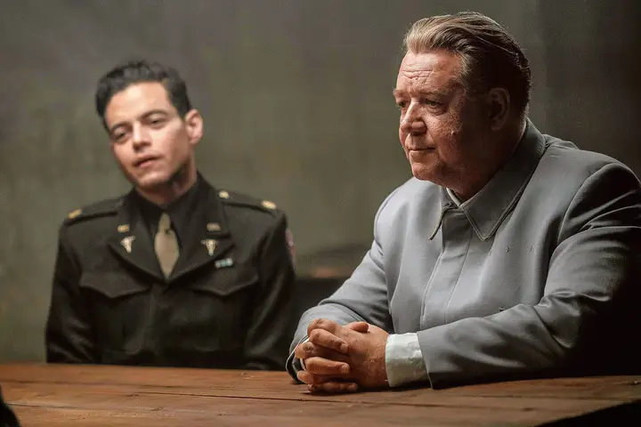 Russell Crowe e Rami Malek frente a frente em cena de interrogatório para o artigo de favoritos de junho.