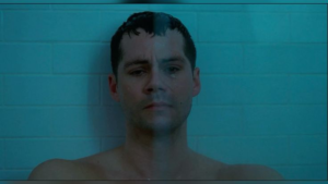O ator Dylan O'Brien com expressão de profunda tristeza e luto no filme Twinless.