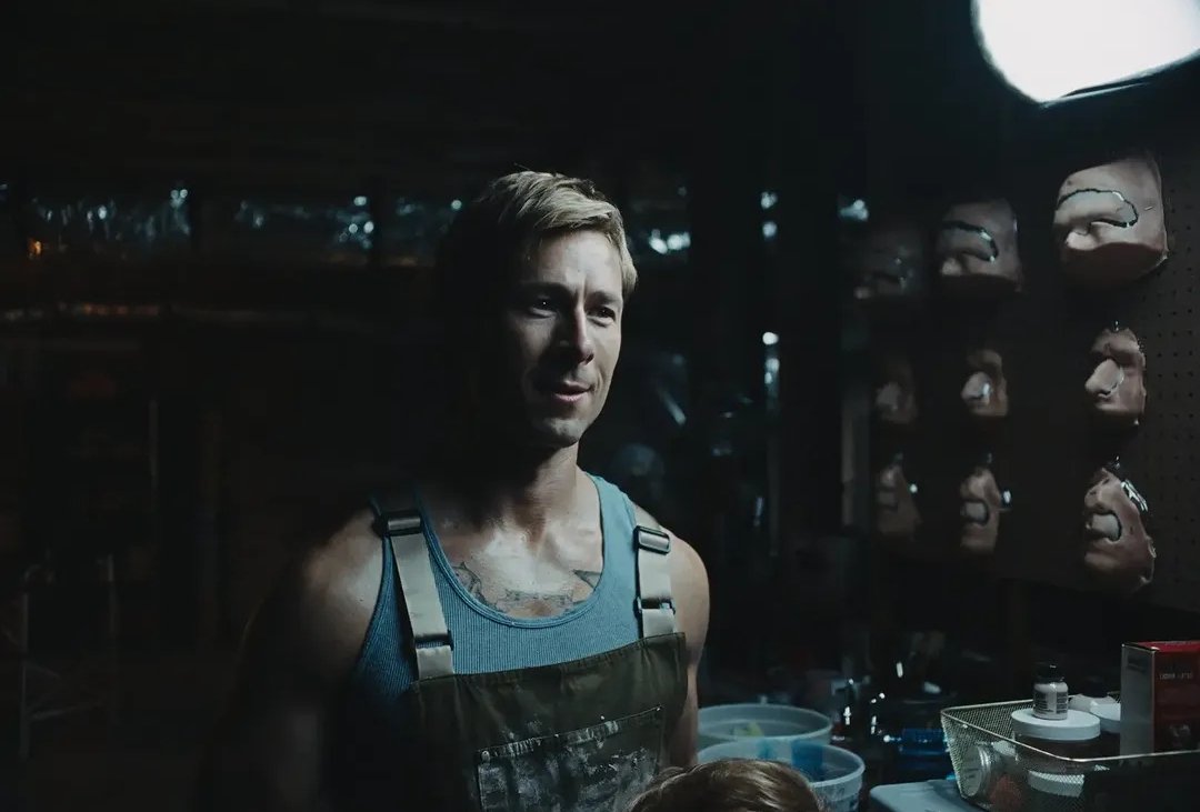 Glen Powell caracterizado como Chad Powers diante de próteses faciais