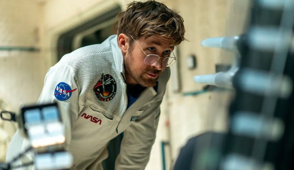 Ryan Gosling com traje da NASA em cena de ficção científica em Devoradores de Estrelas, um dos filmes favoritos de julho.