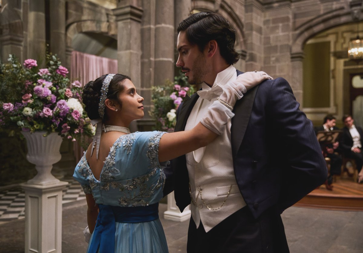 Emilia Sauri dançando com um homem durante um baile em Mal de Amores