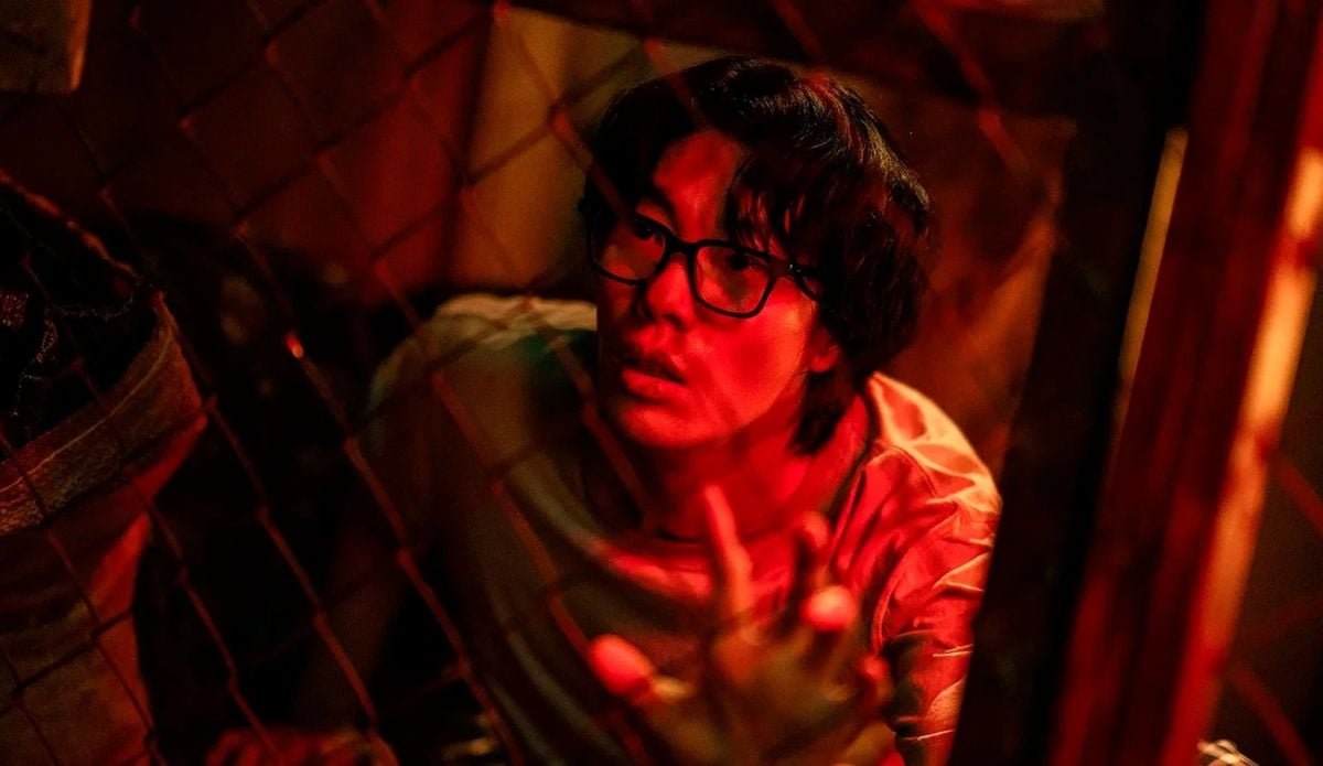 O ator Ryu Jun-yeol em cena tensa sob luz vermelha no suspense O Rato, um dos lançamentos de agosto.