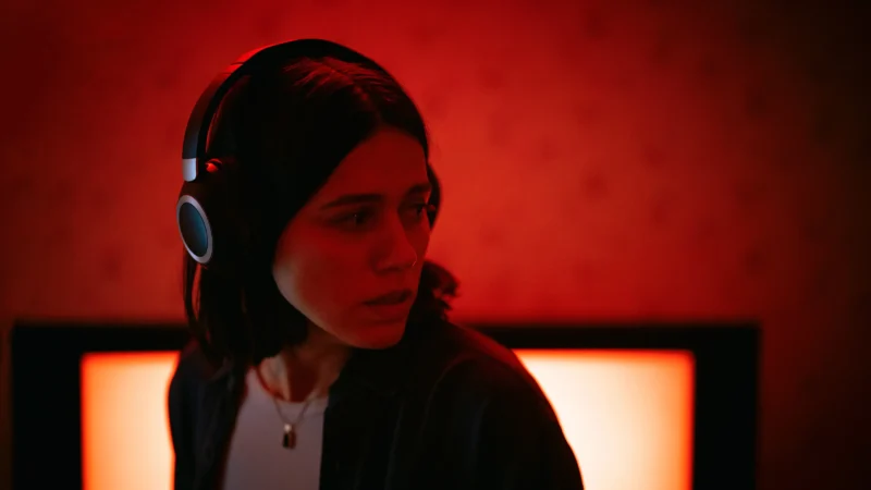 Mulher de fones de ouvido em ambiente sob luz vermelha na série Undertone, um dos destaques dos favoritos de julho.