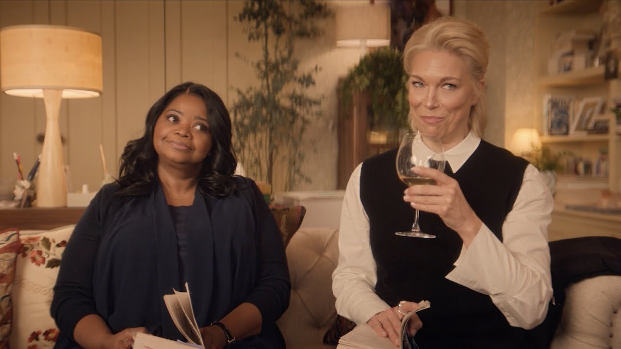 Octavia Spencer e Hannah Waddingham com taça de vinho no sofá em cena de Parceiras no Crime, uma das séries favoritas de julho.