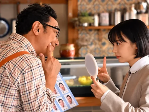 Mana Ashida como Minami Minamida interage com um homem diante de um espelho na série japonesa. Guia dos episódios de Minami na Netflix.