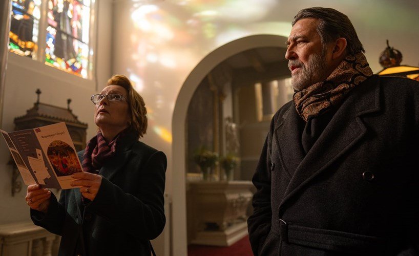 Stella e Gerry dentro de uma igreja durante a viagem do casal em Refúgio de Inverno.